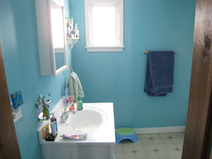 Our bathroom with, technically, the previous homeowners belongings. Tiny towel rack, small vanity, crazy colors.