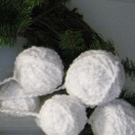 Yarn snowballs on one of the wreaths.