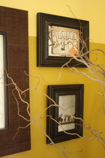 Frames with Anthropologie tear sheets seen through the curly willow branches.