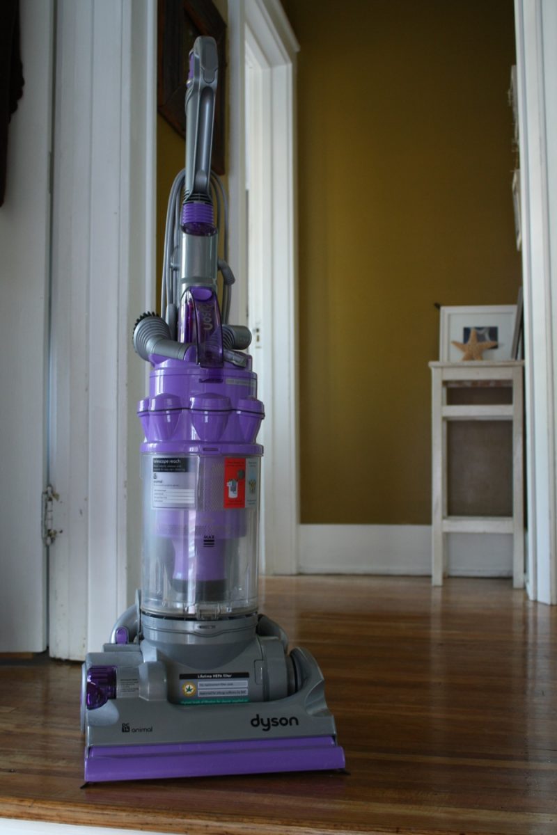 Dyson Animal DC14 sitting on a hardwood floor in a home.