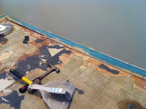 Removing tile and subfloor during a bathroom remodel.