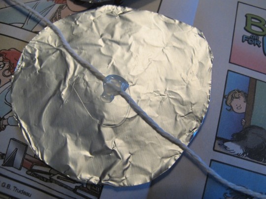 Gluing the foil to the string. 