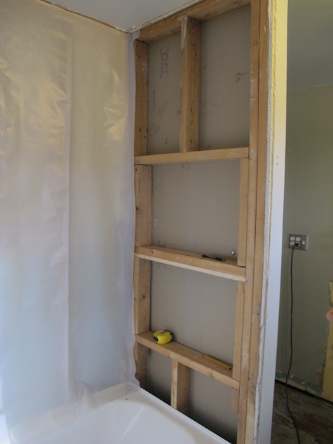Building the frame for custom shelving in a DIY shower renovation.