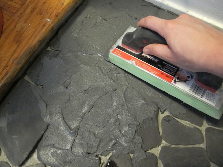 Grouting over the stones in the entryway.