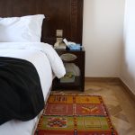 Hand carved headboard, detailed bedside table, and a beautiful Moroccan area rug.