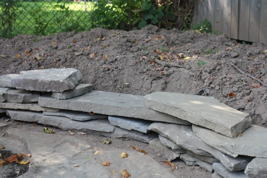 Preventing soil runoff onto our new patio with a small scrap flagstone wall.