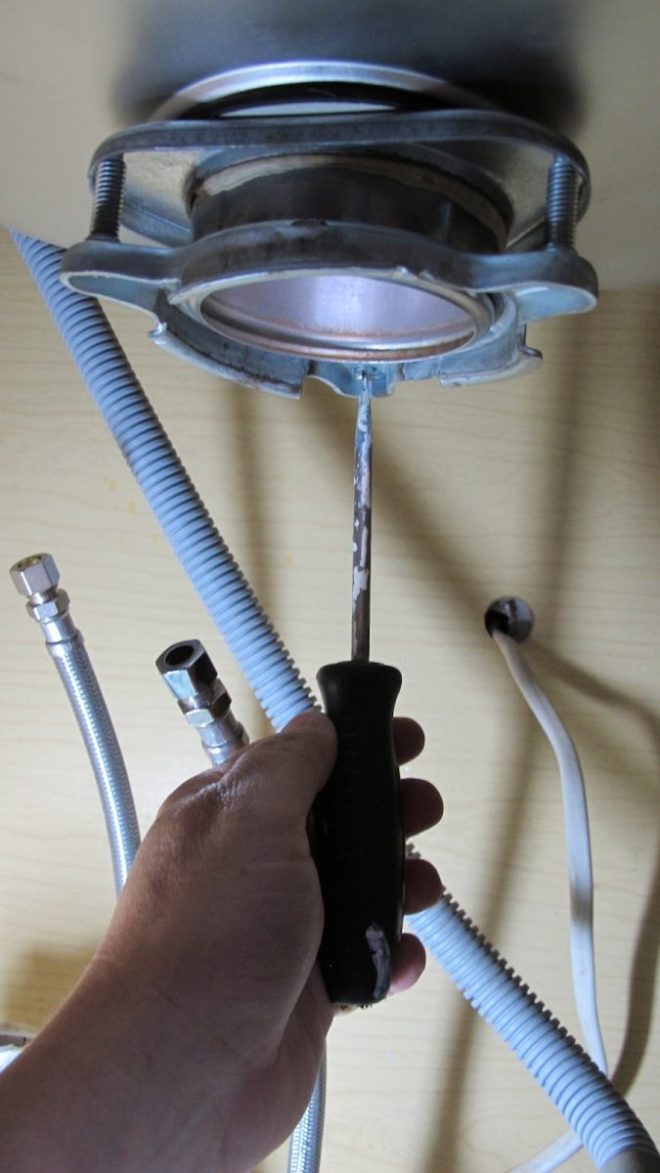 Reinstalling the disposal beneath our new sink.