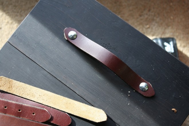 Attaching the belts to the drawers with carriage bolts.