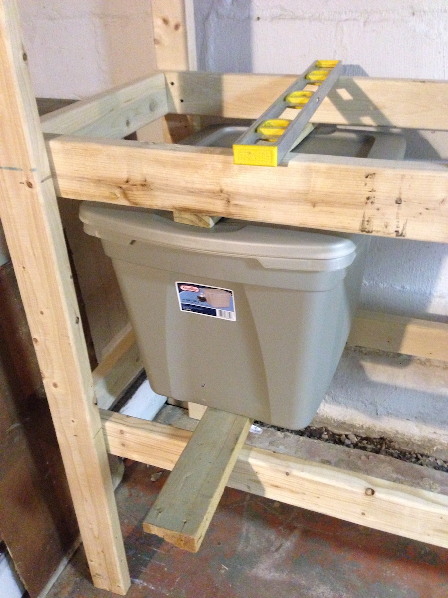 Instalación de estanterías en el sótano para acomodar cubos de plástico grandes.