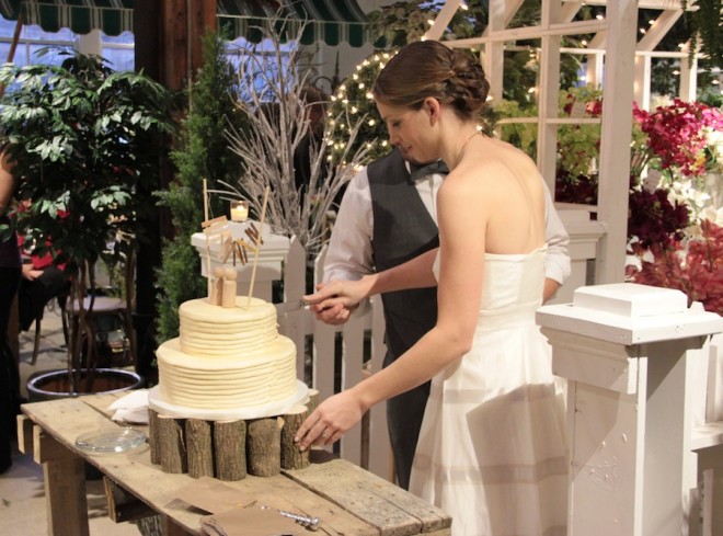 Our beautiful wedding cake, complimented by our DIY wooden cake stand and a custom bunting.