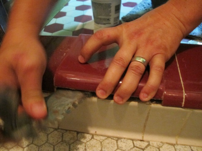 Prying up tiles in the shower to fix leaks.