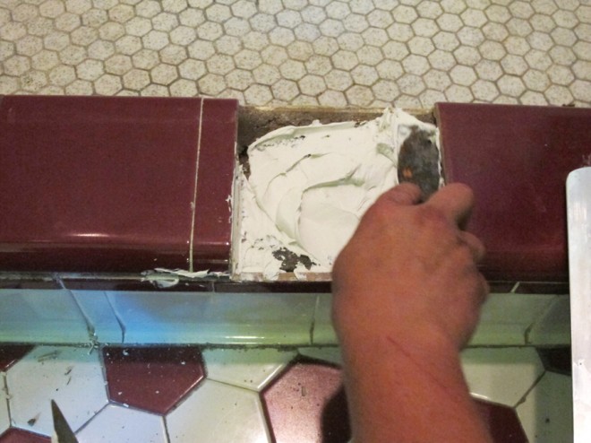 Re-mortaring the threshold tiles in place.