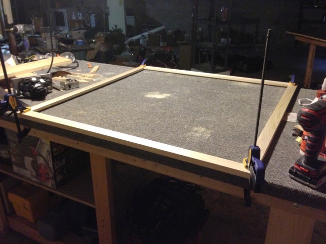 Clamping the corners of the frame in place.