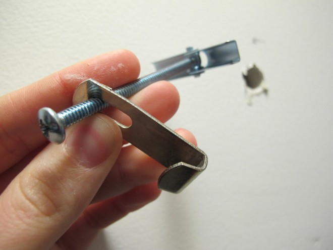 Using toggle bolts to hang a heavy mirror on the wall.