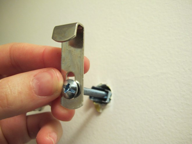 Using toggle bolts to hang a heavy mirror on the wall.