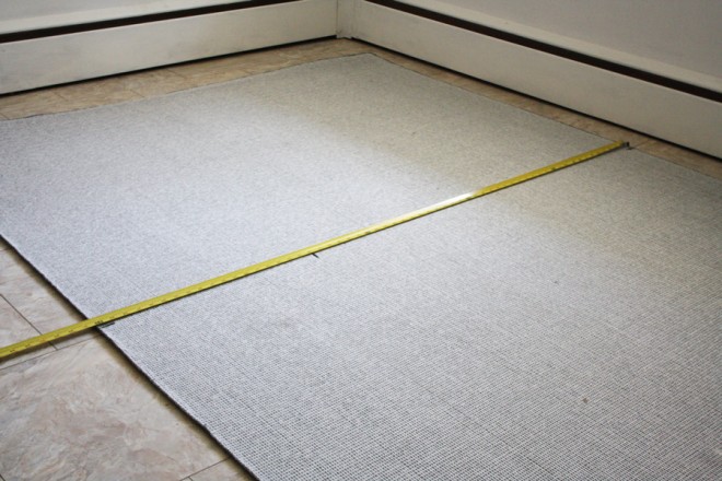 Measuring a rug to be custom cut into a half-circle.