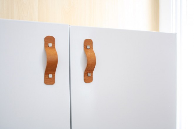 Attaching a leather belt to a cabinet for a unique door pull.