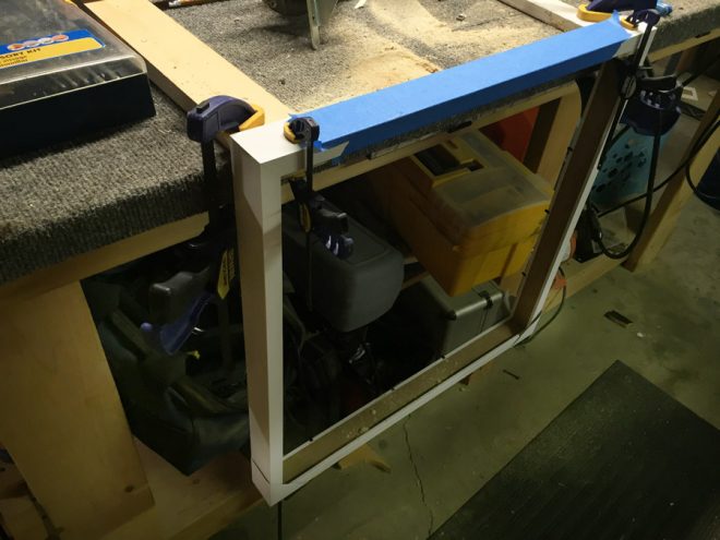 Using a router to cut through a IKEA RIBBA frame.